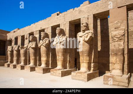Statues d'Osiride bordant la première cour de la chapelle barque de Ramsès III au complexe du temple de Karnak à Louxor, en Égypte Banque D'Images