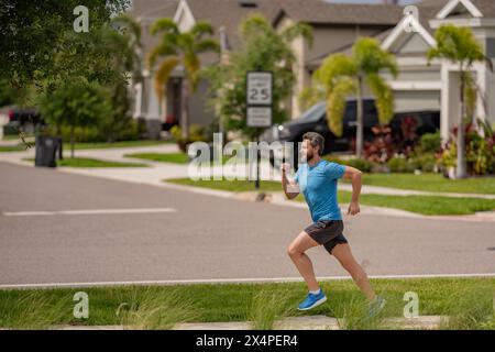 Beau homme d'âge moyen traversant le quartier américain. Homme sportif en plein air. Un mode de vie sain. Jogging actif et sain en extérieur. Banque D'Images