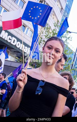 Varsovie, Pologne. 01 mai 2024. Une jeune femme agite à la fois le drapeau polonais et le drapeau européen pendant le rallye. Le 1er mai, la Pologne célèbre la fête du travail. À Varsovie, des travailleurs, des militants politiques et d'autres membres de la gauche se sont rassemblés dans le centre de la ville et ont participé à un défilé en l'honneur des travailleurs du pays. Cette année, le défilé a voyagé du parc ?wi?tokrzyski à l'Institut national du patrimoine culturel et a été dirigé par le député polonais du Parlement européen, Robert Biedron. (Photo de Neil Milton/SOPA images/SIPA USA) crédit : SIPA USA/Alamy Live News Banque D'Images