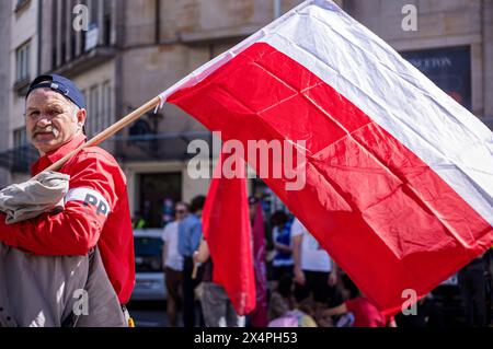 Un partisan du Parti socialiste polonais (PPS) écoute les discours alors que son drapeau souffle dans le vent pendant le rassemblement. Le 1er mai, la Pologne célèbre la fête du travail. À Varsovie, des travailleurs, des militants politiques et d'autres membres de la gauche se sont rassemblés dans le centre de la ville et ont participé à un défilé en l'honneur des travailleurs du pays. Cette année, le défilé a voyagé du parc ?wi?tokrzyski à l'Institut national du patrimoine culturel et a été dirigé par le député polonais du Parlement européen, Robert Biedron. (Photo de Neil Milton/SOPA images/SIPA USA) Banque D'Images