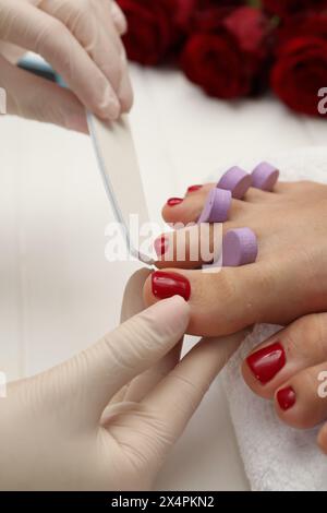 Pédicuriste classant les ongles des orteils du client dans un salon de beauté, gros plan Banque D'Images