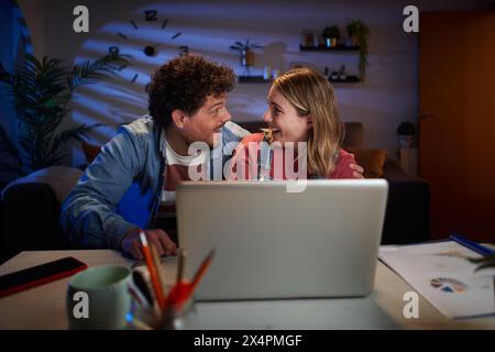 Jeune couple caucasien adulte excité se regardant l'un l'autre dans surpris de célébrer le travail réussi. Banque D'Images