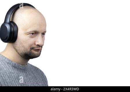 C'est un portrait captivant d'un homme, placé sur un fond blanc dur. Il est vêtu d'un pull en laine grise finement tricoté, son visage exprimant cont Banque D'Images