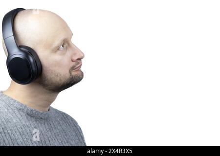 C'est un portrait captivant d'un homme, placé sur un fond blanc dur. Il est vêtu d'un pull en laine grise finement tricoté, son regard dirigé vers le haut Banque D'Images
