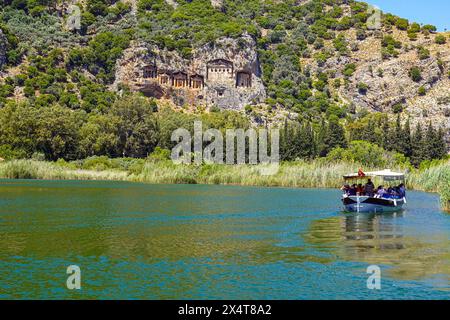 Bateaux fluviaux touristiques et tombes royales lyciennes sculptées dans la paroi rocheuse, à la destination touristique populaire de Dalyan, province de Mugla, Turquie Banque D'Images