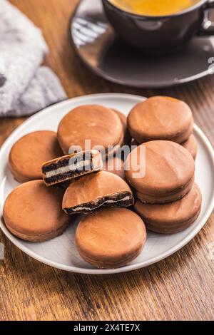 Vue rapprochée de biscuits sandwichs enrobés de chocolat sur une table en bois. Banque D'Images