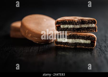 Vue rapprochée de biscuits sandwichs enrobés de chocolat sur un fond sombre Banque D'Images