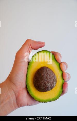 Main d'homme tenant la moitié avocat. Fermer la vue. Banque D'Images