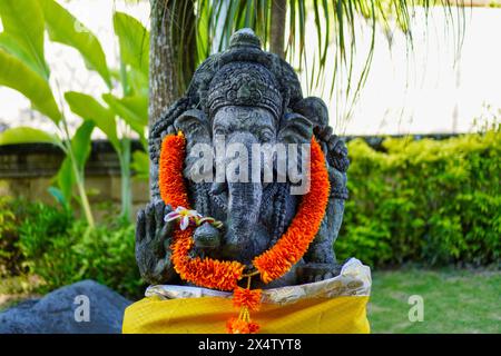Statue du Seigneur Ganesha avec une guirlande jaune, une tradition des croyances religieuses hindoues de Bali Banque D'Images