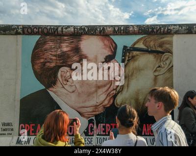 Graffiti emblématique sur le mur de Berlin représentant le baiser fraternel entre Leonid Brejnev et Erich Honecker, symbolisant l'histoire politique en DDR Banque D'Images