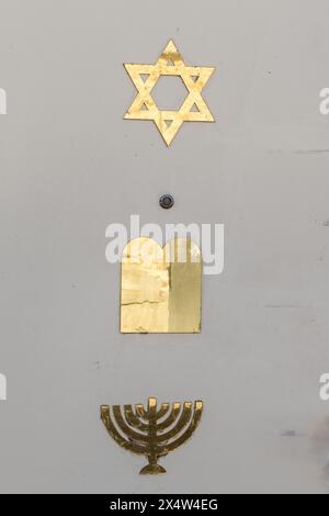 Une porte blanche à Jérusalem, en Israël, décorée de trois symboles en or de la foi juive : une étoile de David à six branches, des tablettes des 10 commandants Banque D'Images