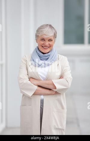 Mature heureuse belle femme d'affaires professionnelle souriante, entrepreneur modèle positif confiant heureux debout à l'extérieur sur les bras de rue croisés, féminin Banque D'Images