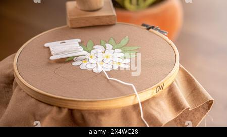 De la brosse à la couture : combinaison de tissu peint avec des fleurs brodées à la main Banque D'Images