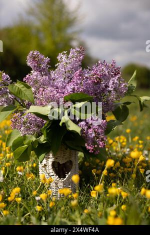 Bouquet de lilas dans un vase en osier, croissant et chapeau. Pique-nique de printemps. Photo de haute qualité Banque D'Images