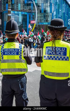 Deux policiers regardant un manifestant pro-palestinien dans une manifestation de rue anti-israélienne - Palestine Solidarity Campaign. Centre-ville de Cardiff. Banque D'Images