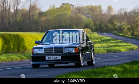 Bicester, UK- 21 avril 2024 : 1990 Mercedes Benz 190 e voiture classique conduisant sur une route britannique Banque D'Images