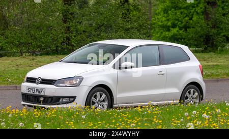 Milton Keynes, Royaume-Uni - 3 mai 2024 : 2013 Volkswagen Polo blanc conduisant sur une route britannique Banque D'Images