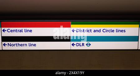 Londres, Royaume-Uni - 25 mars 2024 ; panneau de direction coloré du métro londonien vers les lignes de métro et DLR Banque D'Images