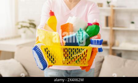 Femme tenant un panier plein de produits de nettoyage recadré Banque D'Images