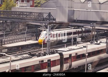 Vue aérienne d'une gare moderne avec plusieurs trains, mettant en valeur un centre de transport urbain très fréquenté. Banque D'Images