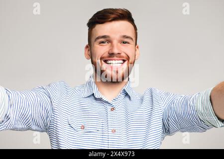 Beau jeune homme tenir l'appareil photo et faire selfies Banque D'Images