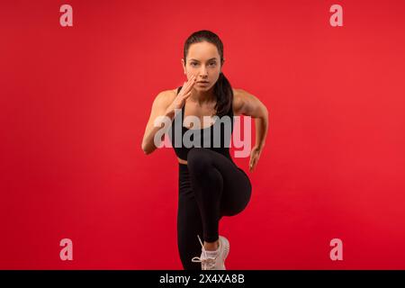 Femme en Top noir et Leggings en cours d'exécution sur Rouge Banque D'Images