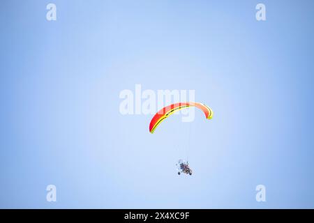 Vol tandem motorisé avec paratrike, parapente motorisé à double siège avec roues. des gens méconnaissables haut dans le ciel sur un tricycle motorisé wit Banque D'Images