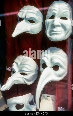 Une photographie d'archives des années 1990 de masques de carnaval blancs non peints dans la vitrine de Ca' Macana, un fabricant traditionnel de masques vénitiens. Banque D'Images