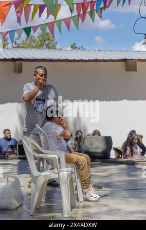 Jujuy, Argentine - 25 janvier 2024 : le parrain et le filleul toast à une fête traditionnelle à Humahuaca. Banque D'Images