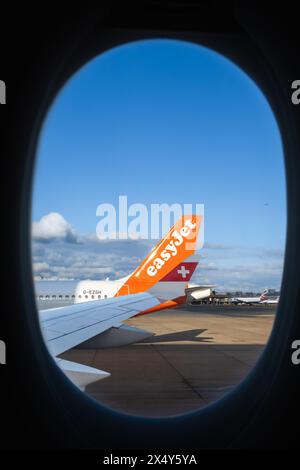 Londres, Royaume-Uni - 29 avril 2024 : un Easyjet et un avion de ligne suisse ont atterri à l'aéroport de Londres Gatwick - vue par la fenêtre Banque D'Images