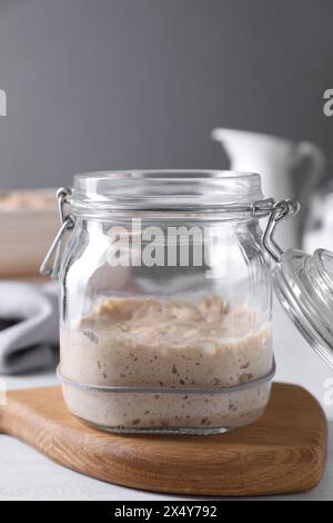 Levain de levain dans un bocal en verre sur une table lumineuse Banque D'Images