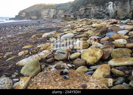 Roches et galets tachés par les mines précédentes à Blast Beach, Seaham, comté de Durham Banque D'Images