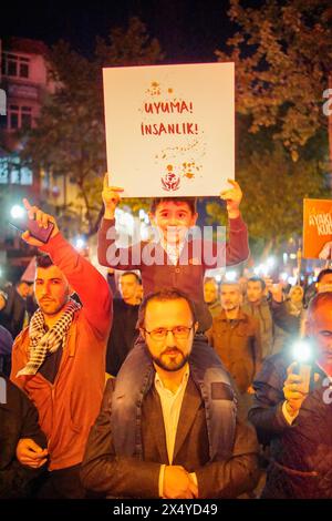 Istanbul, Turquie. 05 mai 2024. Un garçon tient une pancarte qui dit "ne dors pas l'humanité" pendant la marche. Des centaines de personnes ont défilé à Istanbul le soir du 5 mai pour exprimer leur solidarité avec le peuple palestinien. Les manifestants ont condamné les attaques israéliennes et ont appelé à un cessez-le-feu immédiat et à l'accès de l'aide humanitaire. La marche a fait écho aux appels mondiaux en faveur de la paix dans la région. Crédit : SOPA images Limited/Alamy Live News Banque D'Images