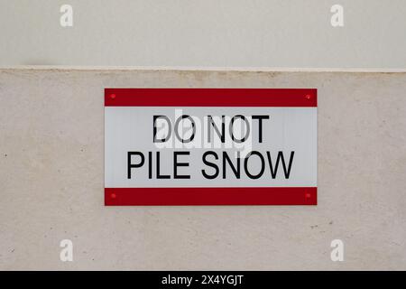 Gros plan des photos d'un panneau de NEIGE NE PAS EMPILER sur le toit d'une structure de stationnement en béton. Banque D'Images