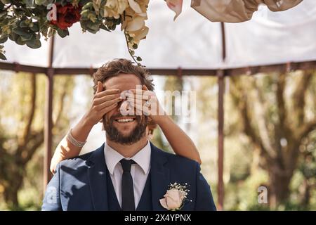 Mariage, surprise et mains couvrent l'homme du secret, l'annonce ou le marié à l'autel du mariage. Cacher, yeux et révéler la personne à l'événement de célébration et Banque D'Images