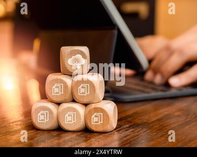Concept de gestion de la technologie de cloud computing. Symbole de nuage et icônes de fichier de document numérique sur la pile pyramidale de blocs de cube en bois près du travail d'homme d'affaires Banque D'Images
