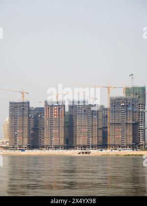 Van Pak Len, Laos - 28 mars 2024 : bâtiments résidentiels hirise sous construction sur les rives du Mékong à Van Pak Len (Laos). Banque D'Images