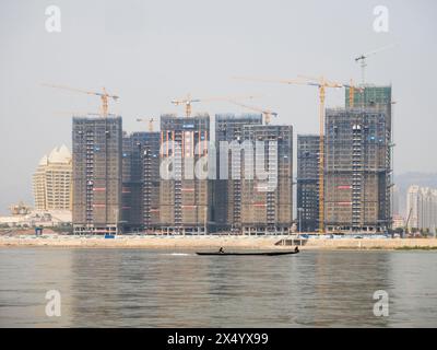 Van Pak Len, Laos - 28 mars 2024 : bâtiments résidentiels hirise sous Construccion et le casino Kings Romans (à gauche) sur les rives du Mékong Banque D'Images