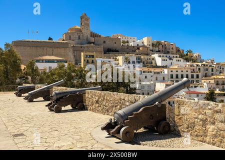 Canons médiévaux sur le mur fortifié comme vieille ville, fortifications et maisons blanches sur fond à Eivissa, Ibiza, Espagne. Banque D'Images