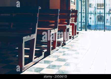 Chaises dans une rangée sur le sol à l'intérieur de l'église. Bancs en bois pour prier Banque D'Images