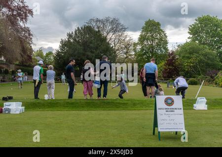 Les familles essayant des bols de pelouse le jour ouvert du Castle Green Bowling Club, Guildford, Surrey, Angleterre, Royaume-Uni, en mai 2024 Banque D'Images