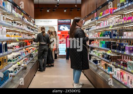 Parfums de différentes marques à vendre dans le magasin de parfum et de cosmétiques. Les clients testent et achètent du parfum en magasin. Minsk, Biélorussie - 19 avril 2024 Banque D'Images