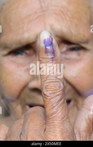 Une femme âgée affiche fièrement son doigt encré après avoir voté aux élections de Lok Sabha dans un bureau de vote de Boxanagar à Agartala. Tripura, Inde. Banque D'Images