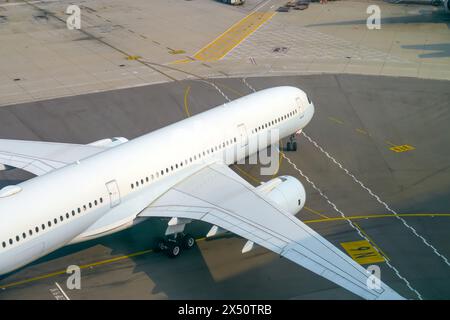 Vue aérienne des panneaux de marquage routier de l'aéroport sur la surface. Avion roulant jusqu'au terminal Banque D'Images