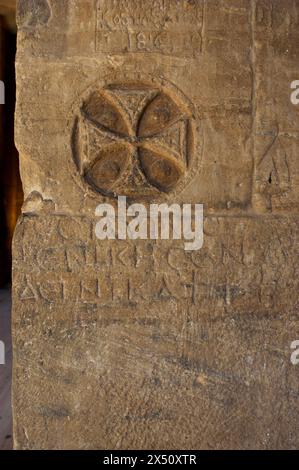 Égypte. Philae Temple, dédié à la déesse Isis. Érigé pendant les périodes ptolémaïque et romaine. Île d'Agilkia. Assouan. Croix chrétienne sculptée sur l'un des murs du sanctuaire. Dans les premiers jours du christianisme, il était courant de graver des symboles chrétiens sur les lieux de culte profane. Au vie siècle, l'empereur Justinien prohibe le culte à la déesse Isis, convertissant le complexe en une église chrétienne dédiée à Saint-Étienne, jusqu'au XIIe siècle, lorsque l'islam devient la religion majoritaire de la population égyptienne. Banque D'Images