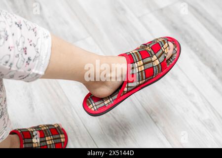 tige de pied dans une vieille pantoufle qui fuit. vieille pantoufle. l'orteil sort de la chaussure dans la pantoufle. Photo de haute qualité Banque D'Images