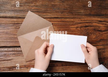 Femme avec carte vierge à la table en bois, vue de dessus. Espace pour le texte Banque D'Images