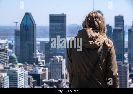 Montréal, CA - 125 avril 2024 : jeune femme regardant les gratte-ciel de Montréal et profitant d'une chaude journée de printemps au belvédère Kondiaronk. Banque D'Images