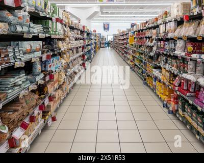 Italie - 24 avril 2024 : allée avec étagères contenant des emballages de pâtes, de riz et de farine dans le rayon alimentation d'un supermarché italien Banque D'Images