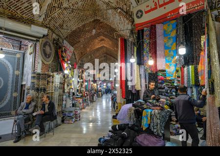 Urmia, Iran - 20 avril 2024 : hommes vendant des tapis et des tissus dans le Bazar historique d'Urmia, Iran. Banque D'Images